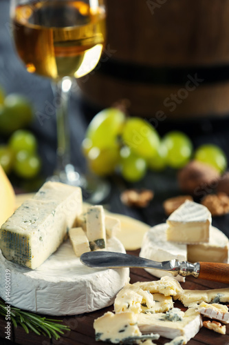 Different types of cheese with knife on blurred background