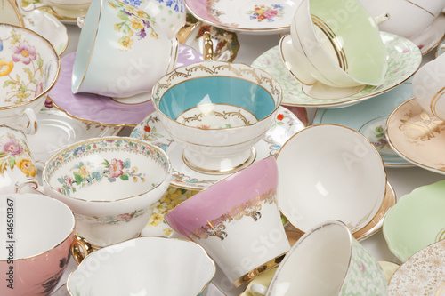 High resolution close-up of a beautiful antique tea cups and saucers collection, isolated on a white background.