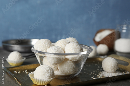 Bowl with coconut candies on metal tray
