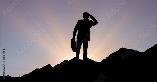 Silhouette businessman standing on mountain 
