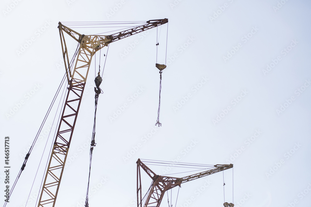 Crane against blue sky. The erection of a new building. Streaming urbanization. Crane against blue sky. The erection of a new building. Streaming urbanization.