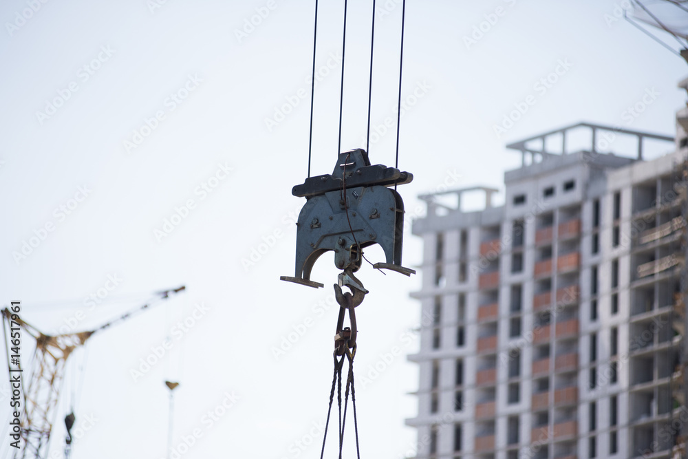 The elements of the crane and building construction site against blue sky. The erection of a new building. Streaming urbanization. The elements of the crane and building construction site against blue sky. The erection of a new building. Streaming urbanization.