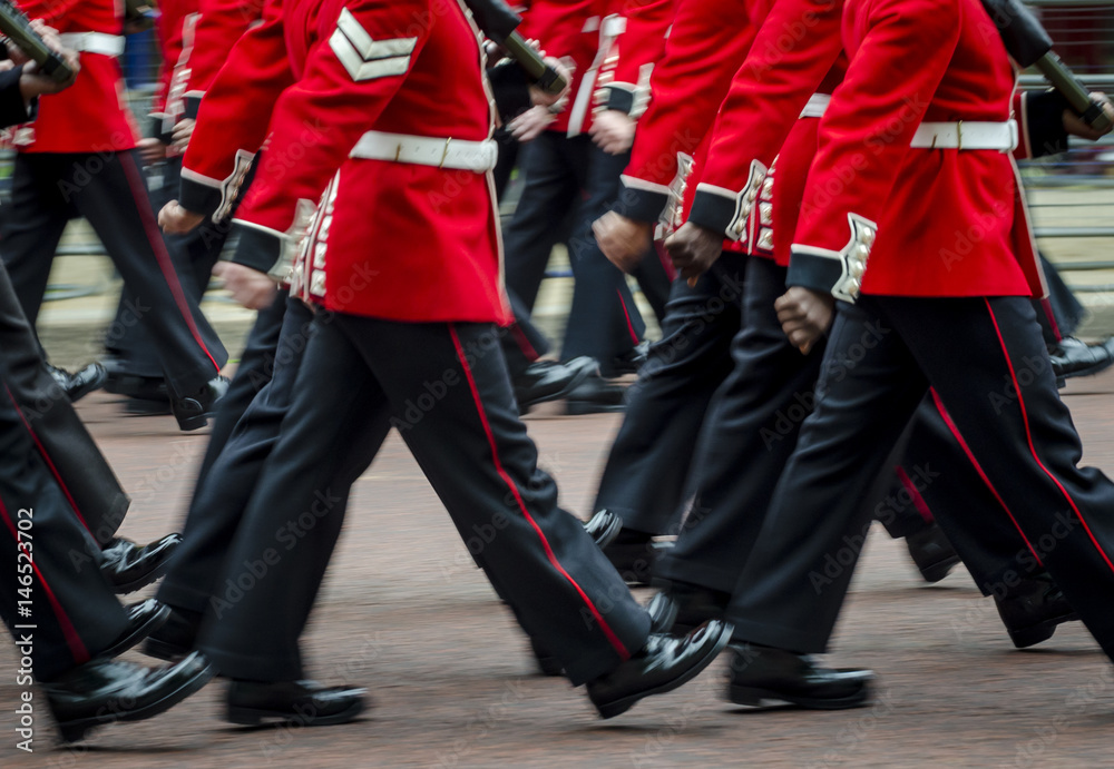 Obraz premium Queen's Royal Guard soldiers walking in red coat uniforms in motion blur in London, England
