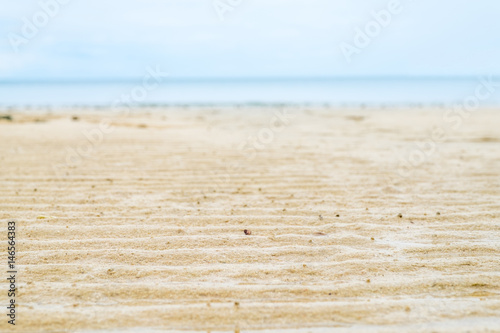 Close up beach sand with blur sea at background