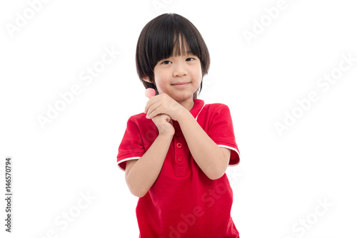 Asian child eating a lollipop on white background