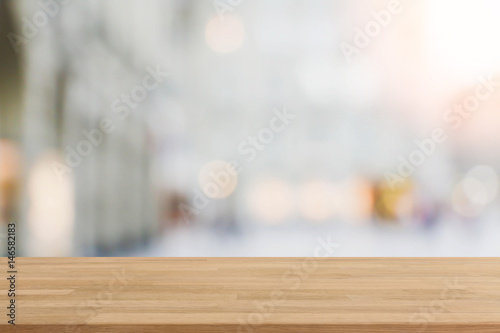 Wood table top and blurred shopping plaza background - can used for display or montage your products.