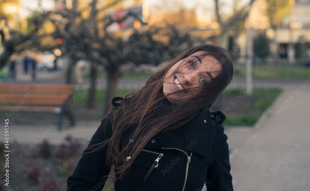 emotions of beautiful young girl in the city - fooling around. strong wind blows her hair. The head is lowered to one side. emotions of beautiful young girl in the city - fooling around. strong wind blows her hair. The head is lowered to one side.
