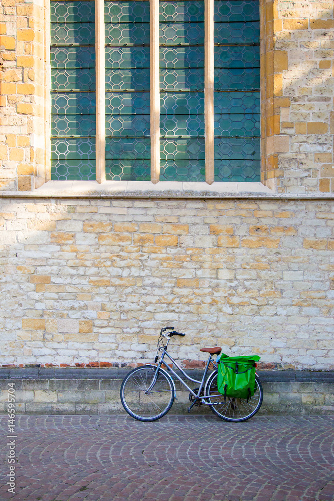 Bicycle leaning on old stone wall