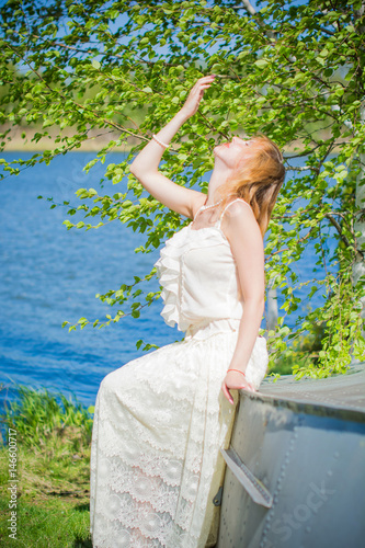 Gentle girl bride in vintage lace dress in the style of Provence with a pearl necklace and a bracelet in the garden stylized wedding on the farm photo