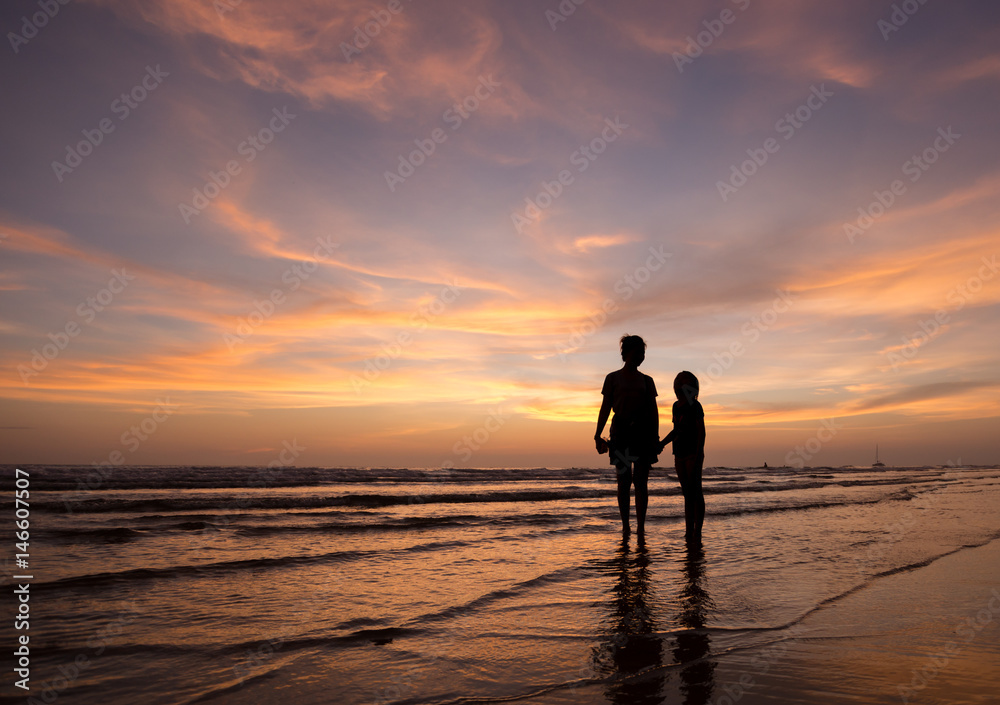 silhouette of mother and child walking on the tropical beach sunset background silhouette of mother and child walking on the tropical beach sunset background
