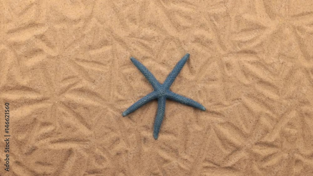 Rotation of a blue starfish lying on the sand. Rotation of a blue starfish lying on the sand.