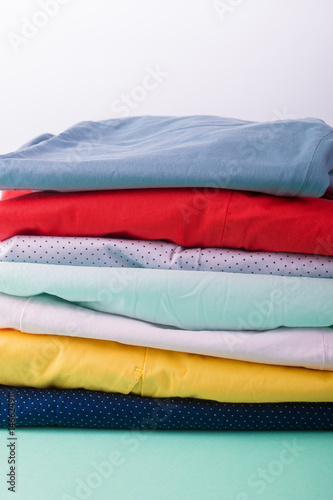 Folded colorful pants and jeans. Stack of bright female trousers. Close up.
