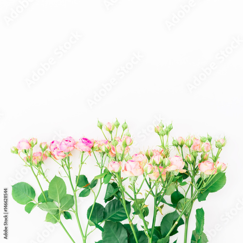 Flowers background. Bouquet made of pink roses  leaves and buds on white background. Flat lay  top view.