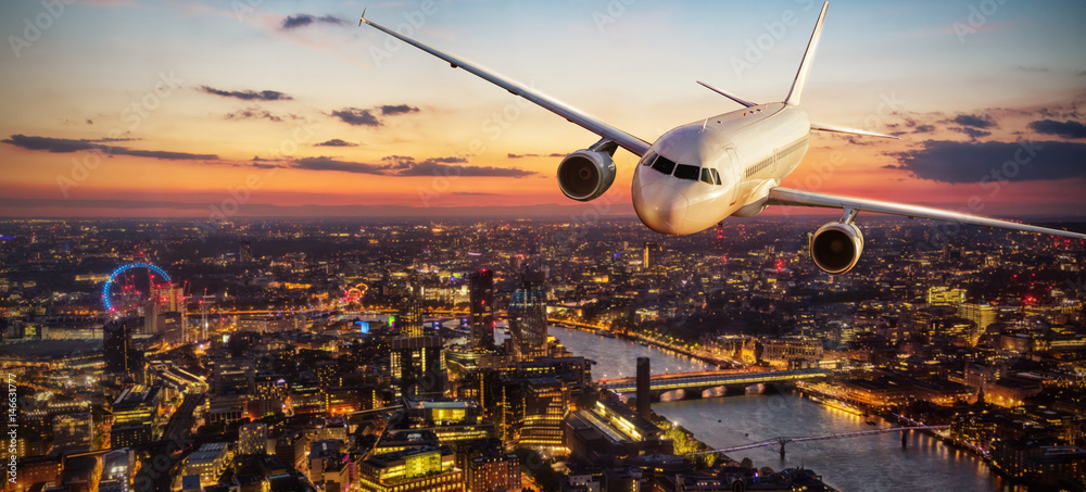 Obraz premium Samolot pasażerów lecący nad Londynem w świetle słońca
