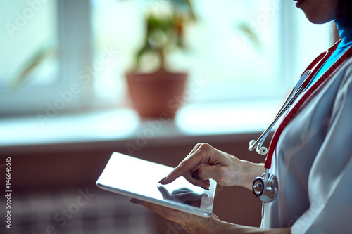 Doctor working on a digital tablet with copy space