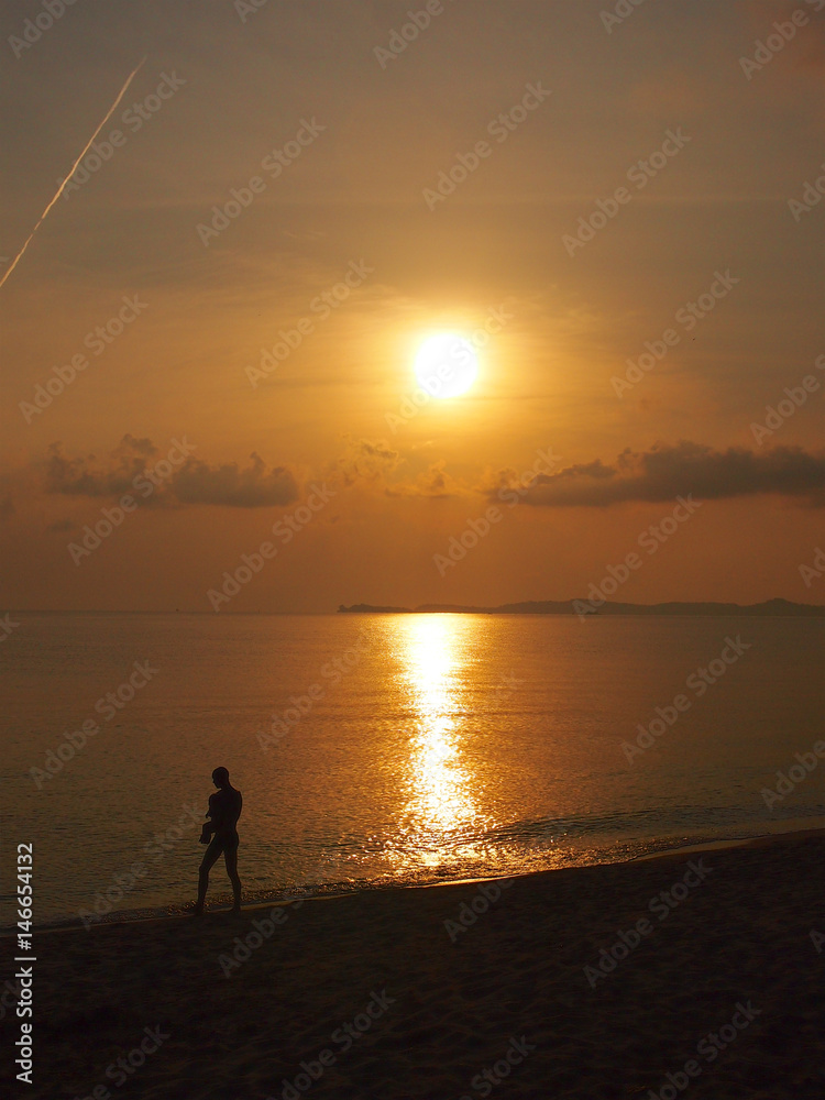 Ａ men carry a baby in front walking in the dusk at Ko Samui beach,Thailand