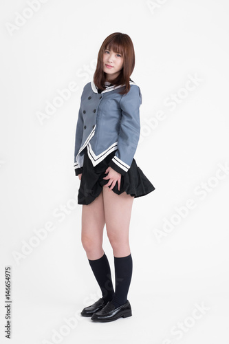 若い女性が、制服を着ています。この画像は、白背景です。女性がAKBのような衣装を着ています。