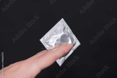 Guy holding a condom