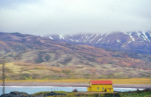 Gelb-rotes Haus steht am Ufer des Fjords  Borgarfjörður/ Borgarfjördur,  vor imposanter Kulisse aus Rhyolith-Bergen, Ostisland, Austurland, Ostfjorde, Island, Iceland, Europa photo