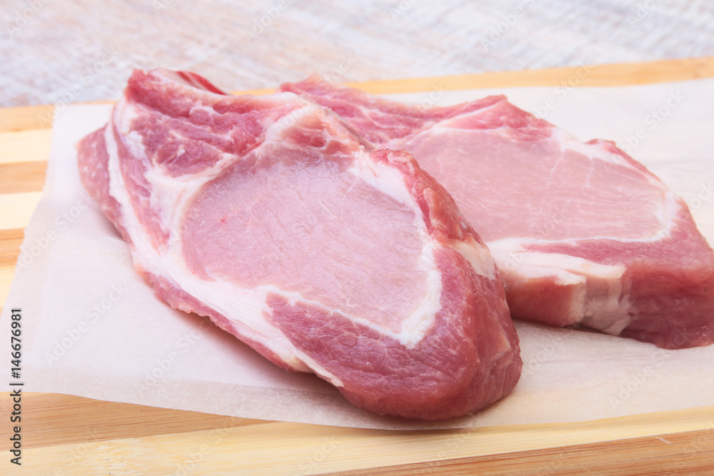 Raw pork chops, spices on cutting board. Ready for cooking. Raw pork chops, spices on cutting board. Ready for cooking.