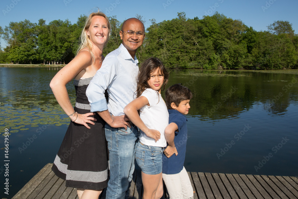 mixed family of Indian origin in front of the park lake during the summer holidays mixed family of Indian origin in front of the park lake during the summer holidays