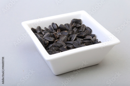 Bowl with sunflower seeds isolated white background.