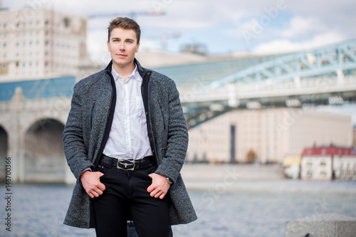 мужчина на набережной на фоне моста