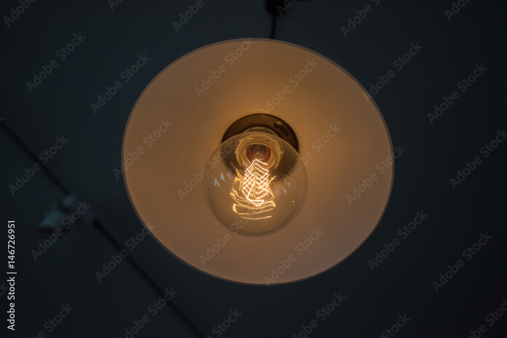 Decorative vintage style glowing light bulb, close-up view.
