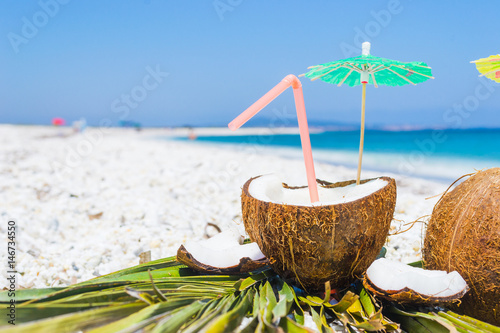 cocktail umbrellas and straw in a coconut