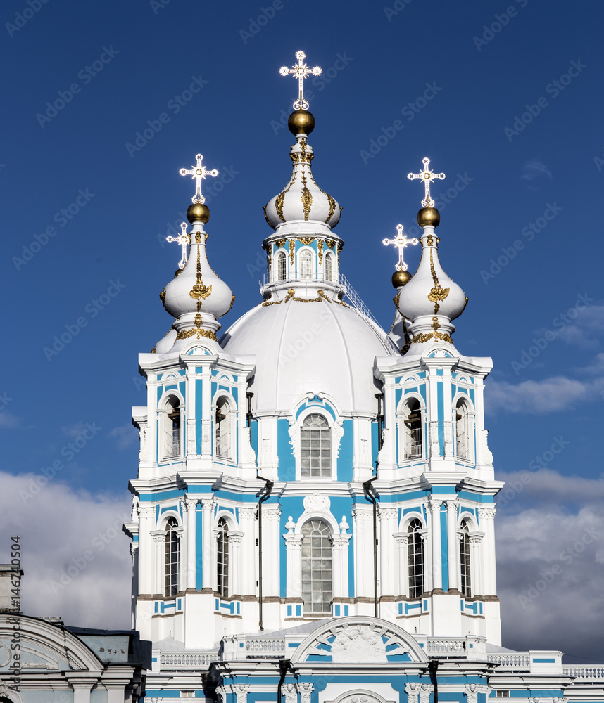 Fototapeta premium Russia,Saint Petersburg. Smolny Cathedral (Church of the Resurrection). Cathedral facade. Clear blue sky and golden crosses.