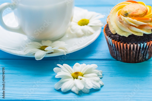 Still life with cup of tea and cake on the wooden background