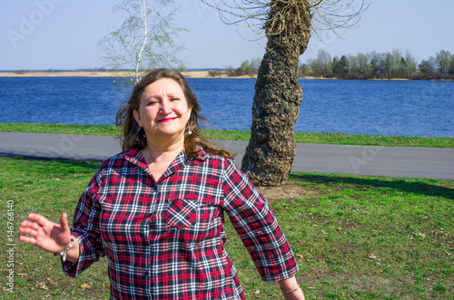 A portrait of a happy smiling woman on a background of river photo