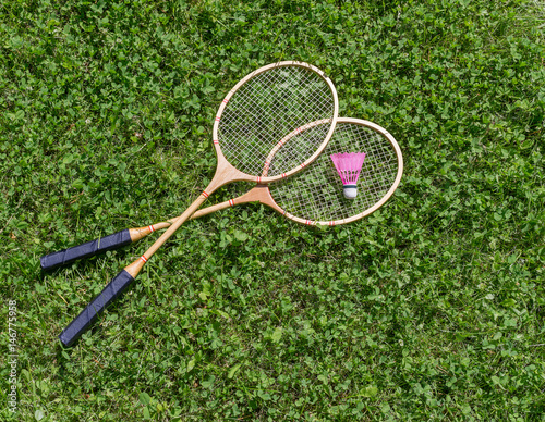 Badminton rackets and shuttlecock on grass