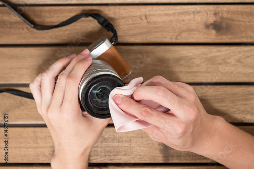 Hand cleaning camera len with cloth