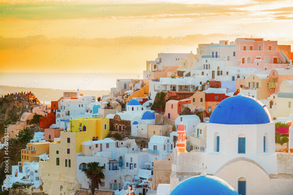 vew of Oia, traditional greek village of Santorini, with blue domes of churches in pink sunset light, Greecer, retro toned
