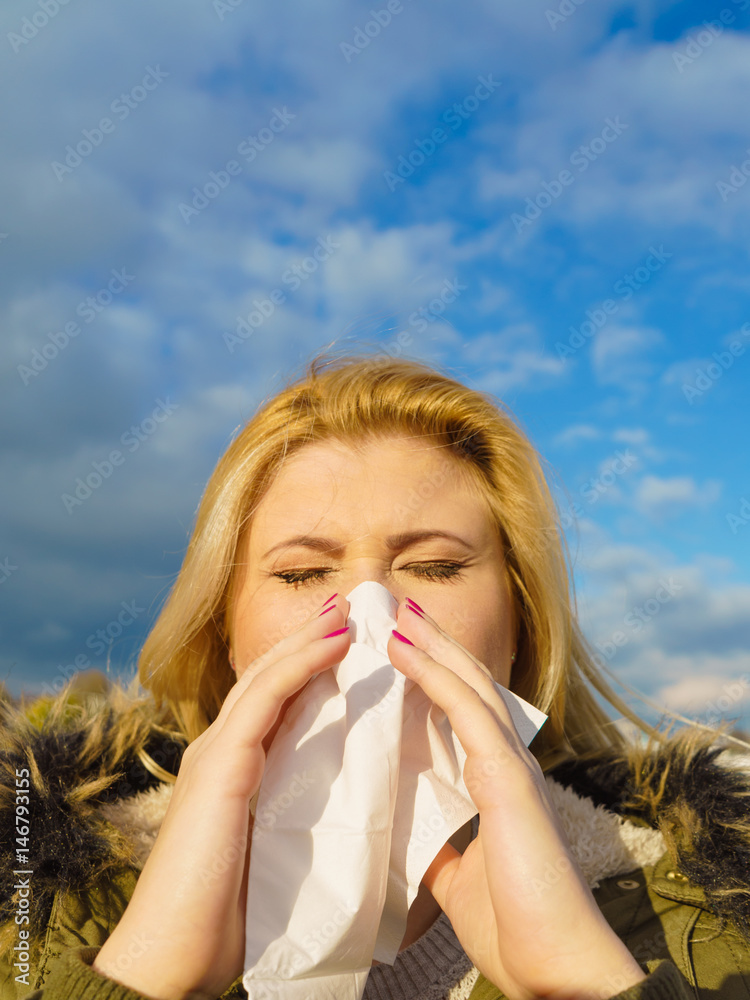 Sneezing woman into handkerchief, outside sunny shot Sneezing woman into handkerchief, outside sunny shot