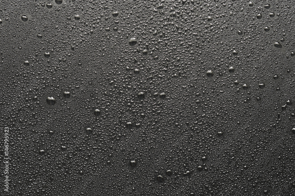 Drops of water on a black surface. The condensate. Top view. Free space.