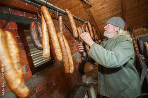 Man checking on sausages in attick photo