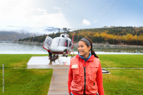 Happy helicopter tourist woman on Alaska tour excursion. Asian girl tourist cruise passenger on shore activity doing helicopter ride in Alaska, USA.