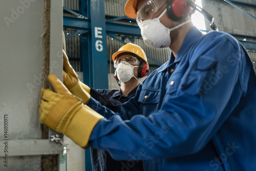 Two blue-collar workers wearing protective equipment