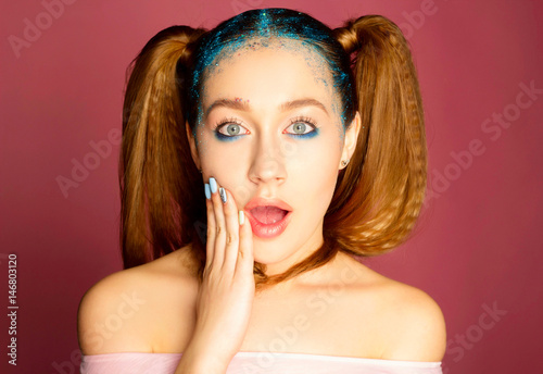 Portrait of beautiful woman with blue make up on eyes and blue glitter in hair. Beauty concept. photo