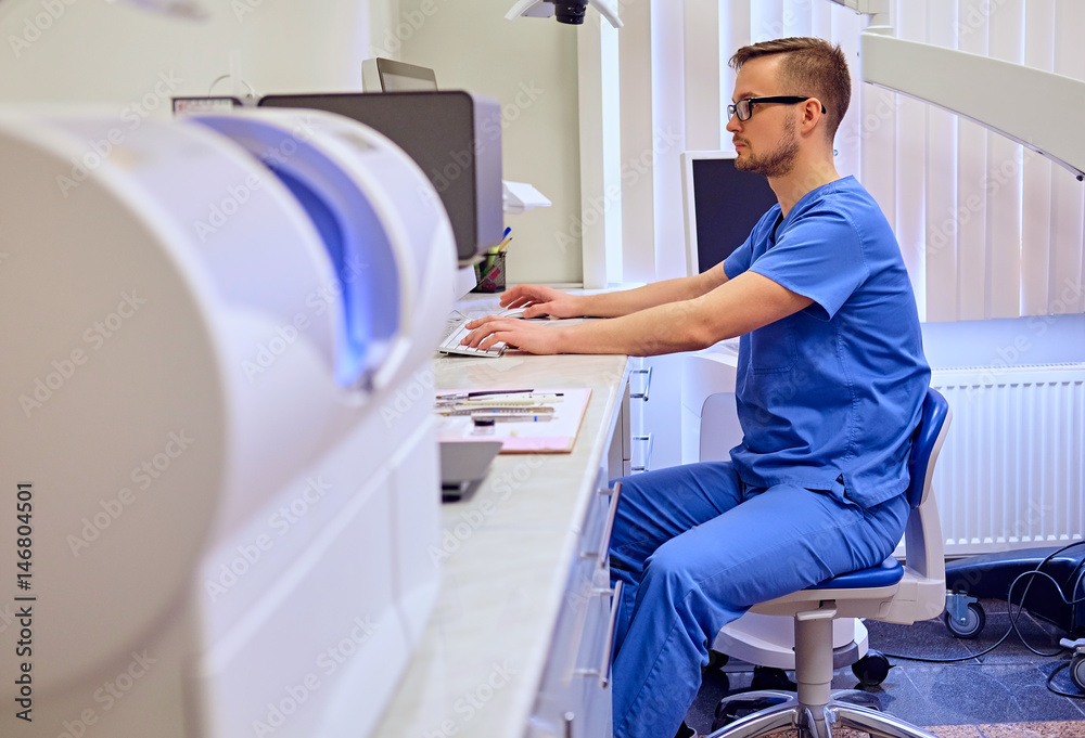 Obraz premium Male dentist in a room with medical equipment on background.