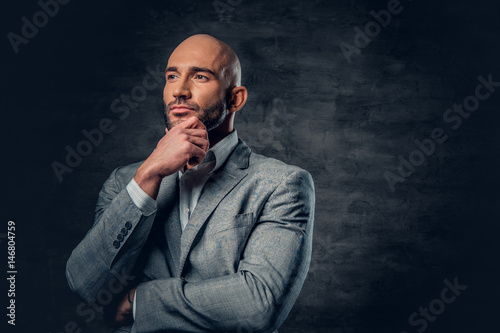 Positive shaved head male dressed in a grey suit.