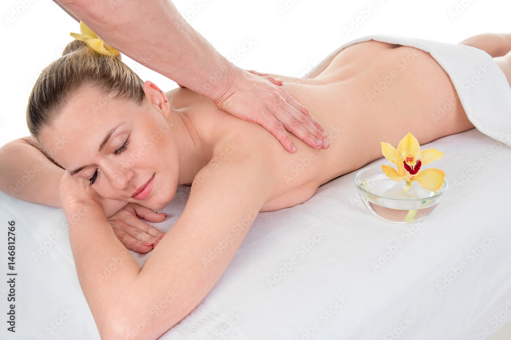 Side view of an attractive young woman receiving back massage at spa saloon Side view of an attractive young woman receiving back massage at spa saloon