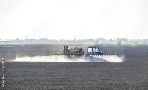 The tractor sprayed herbicides on the field. Chemistry in agricu photo