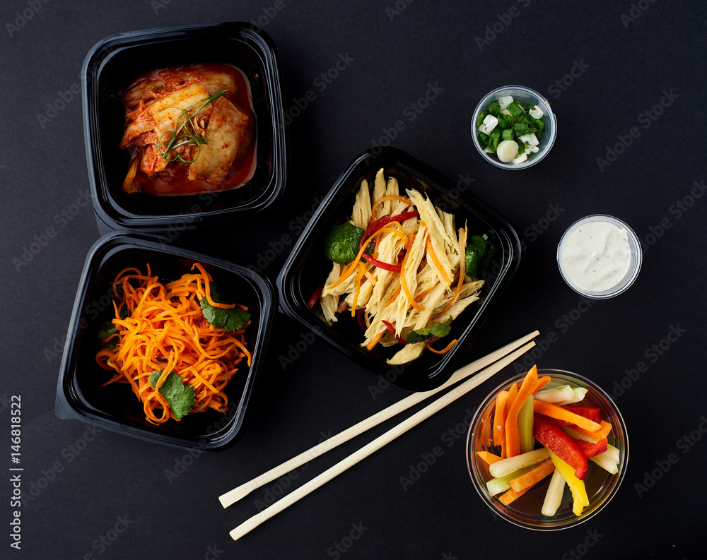 Korean cuisine. Set of salads on black background. Asparagus, korean carrot, kaktugi, fresh vegetable sticks and green onion. Korean cuisine. Set of salads on black background. Asparagus, korean carrot, kaktugi, fresh vegetable sticks and green onion.
