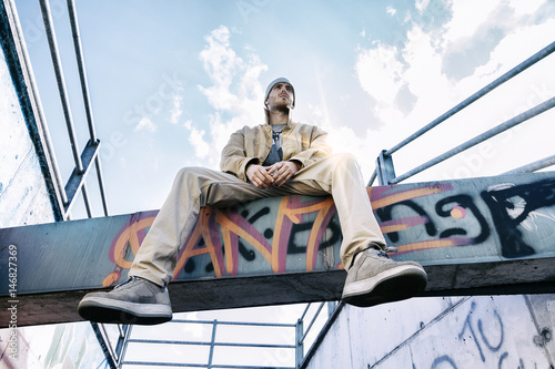 a rap singer on a concrete beam in a subway