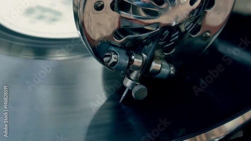 Tonearm needle of the old vintage gramophone slides along the track of the retro plate close-up