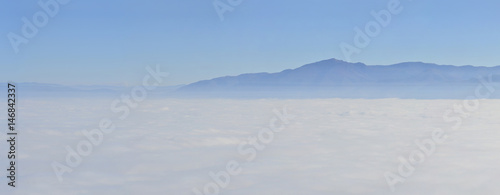 mountain landscape with waves of fog  aerial pov