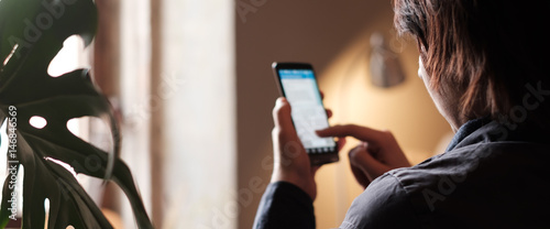 Fotografie The girl looks for important information in the phone, she is photographed from